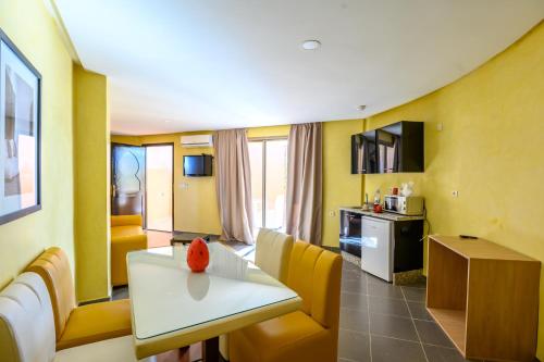 a living room with a white table and yellow walls at Villa Kesh Evasion Marrakech in Marrakech