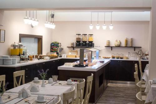 a restaurant with tables and chairs and a kitchen at Hotel Europe in Paralia Katerinis