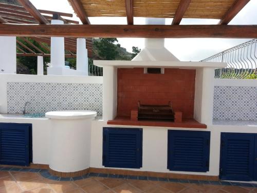 an outdoor kitchen with a stove in a house at Villa Petrara in Acquacalda