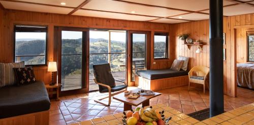 a room with a bed a chair and a table at Turon Gates - Mountain Retreat in Capertee