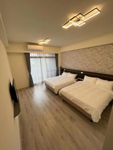 a bedroom with two beds and a large window at 北緯23點5度民宿-車位可預訂 in Hualien City