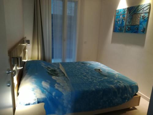 a bedroom with a bed with a blue comforter at Suite Smeralda sea view in Castelsardo