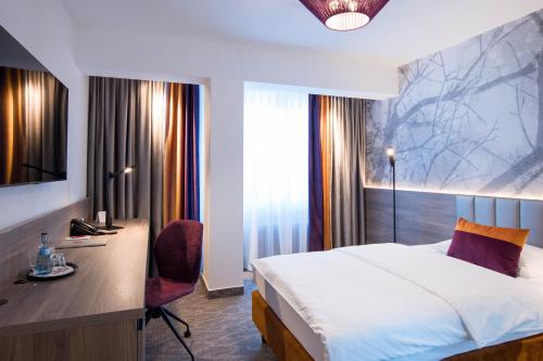 a hotel room with a bed and a desk and window at Hotel Boehler in Böblingen