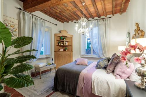 um quarto com uma cama e um lustre em Casa Kathy, Smart and Convenient Luxury 2 Bedrooms Apartment inside the City Walls em Lucca
