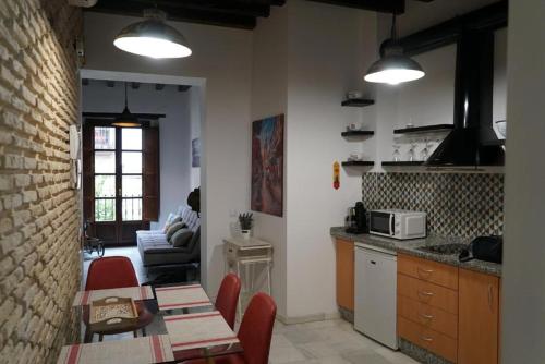 cocina y sala de estar con mesa y sillas en Balcón Giralda Center & Sweet en Sevilla