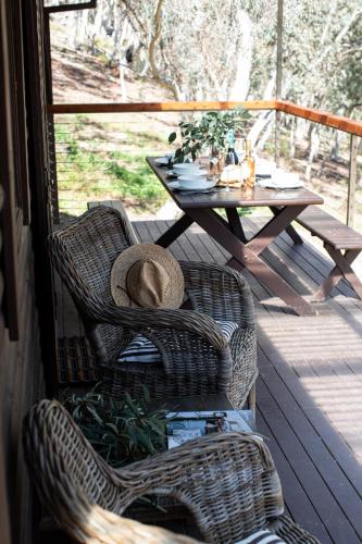 a hat sitting in two wicker chairs on a porch at Turon Gates - Mountain Retreat in Capertee