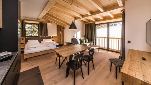 salon z drewnianym stołem i łóżkiem w obiekcie Im Wiesengrund Apartments w mieście Sesto