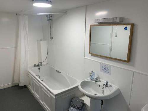 een badkamer met een bad, een wastafel en een spiegel bij The Old Ship Inn in Dorchester