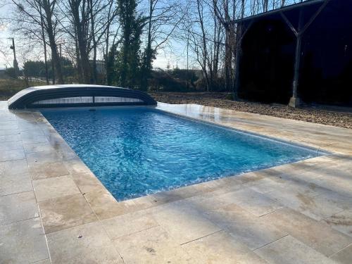 une piscine avec de l'eau bleue dans une cour dans l'établissement La clé des jardins, à Nouâtre