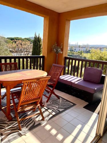 a deck with a table and chairs and a bench at loumax in Gassin