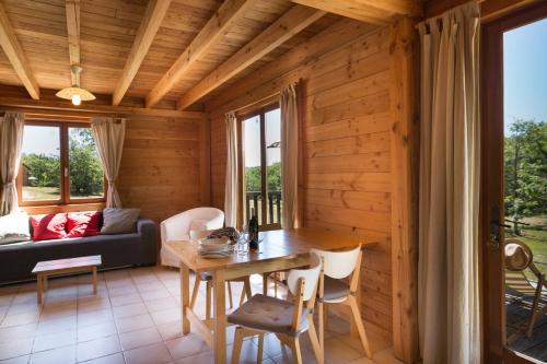 a living room with a table and a couch at Le Bois de Faral in Le Bastit