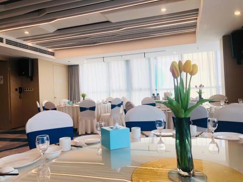 a conference room with a table with a vase of flowers at Holiday Inn Express Linyi North New District by IHG in Linyi