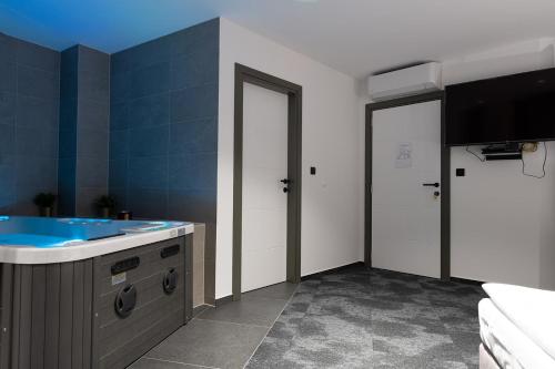 a bathroom with a sink and two white doors at SAVOY residence in Osijek