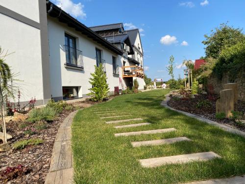 a lawn with stepping stones in front of a house at Pivovar Tupadly in Tupadly