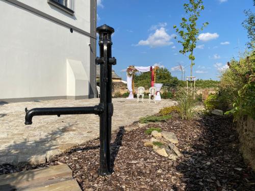 a black pipe in a yard with a wedding ceremony at Pivovar Tupadly in Tupadly