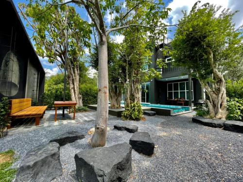 einen Garten mit Felsen und einer Bank vor einem Haus in der Unterkunft Seava House Ao-Nang Krabi in Ao Nang Beach
