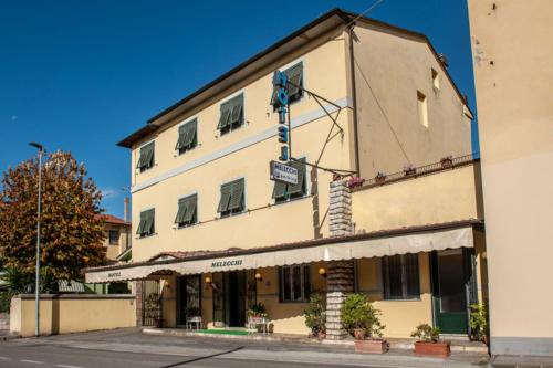 a large building on the corner of a street at Hotel Melecchi in Lucca