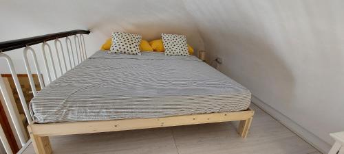 a bed with yellow pillows on it in a room at Casa Daniela 2 in Vieste