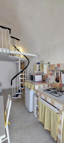 a kitchen with a stove and a spiral staircase at Casa Daniela 2 in Vieste