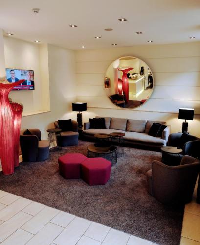 a living room with a couch and a mirror at Hotel Hamburger Hof in Frankfurt/Main