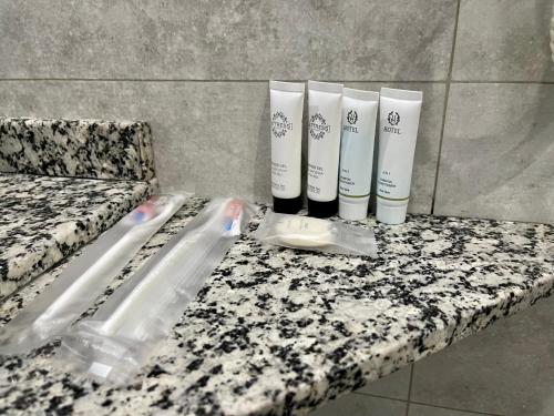 a bathroom counter with three bottles ofodorizers on it at Terrasse Hotel & Bar in Bishkek