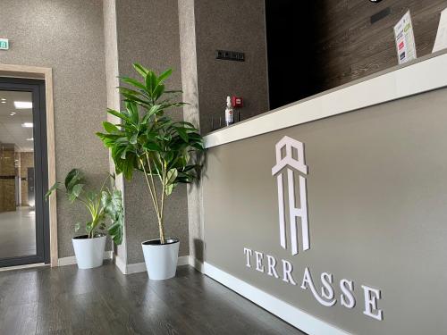 a entrance to a gym with two potted plants at Terrasse Hotel & Bar in Bishkek