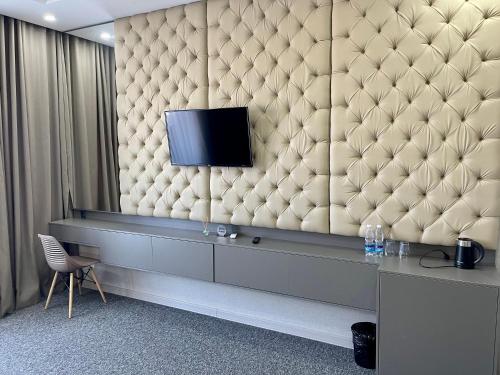 a living room with a tv on a wall at Terrasse Hotel & Bar in Bishkek