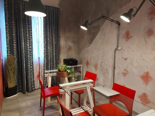 a dining room with red chairs and a table at Bnbook Residence La Red in Rho