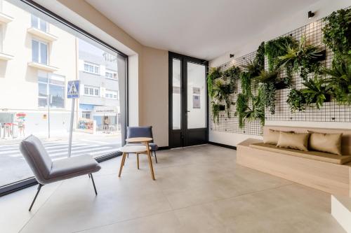 a living room with plants on the wall at Hospedium H Cabo Sport in Finisterre