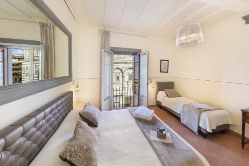 a room with a couch and a bed and a window at B&B Soggiorno Battistero in Florence