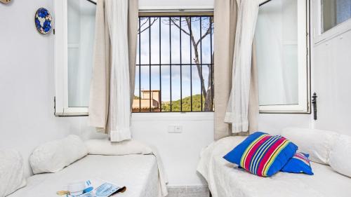a room with two beds and a window at Anc 13 BP - Llafranc in Calella de Palafrugell