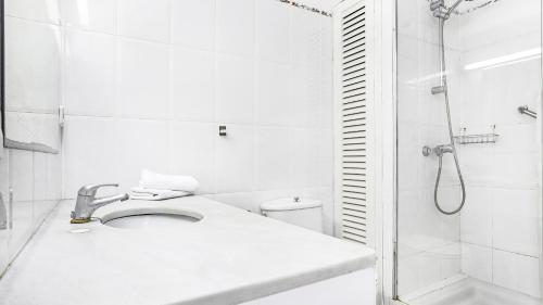 a white bathroom with a sink and a shower at Anc 13 BP - Llafranc in Calella de Palafrugell