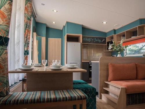 a dining room with a table and a kitchen at Whitecliff Bay Holiday Park in Bembridge