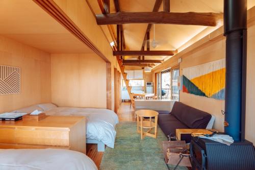 a room with two beds and a couch at ROKKONOMAD in Kobe