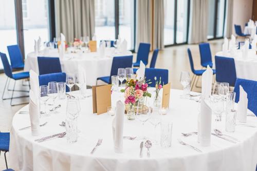 a room with white tables and blue chairs at Hotel & Restaurant Posthalterei in Zusmarshausen