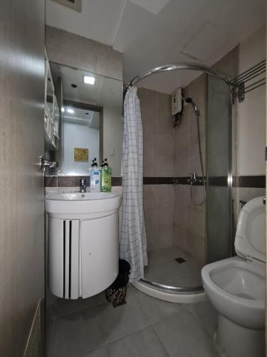 y baño con lavabo, ducha y aseo. en Solemare Parksuites Condominium - Condo R Us, en Manila