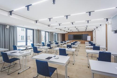 a large room with tables and chairs and a screen at Hotel & Restaurant Posthalterei in Zusmarshausen