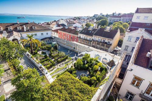 an aerial view of a city with buildings and the ocean at Graça and Alfama Heritage 3-BR Signature Suites by NestAtLisbon in Lisbon