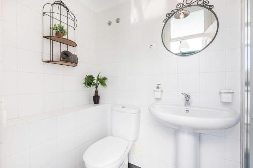 a white bathroom with a toilet and a sink at Graça and Alfama Heritage 3-BR Signature Suites by NestAtLisbon in Lisbon