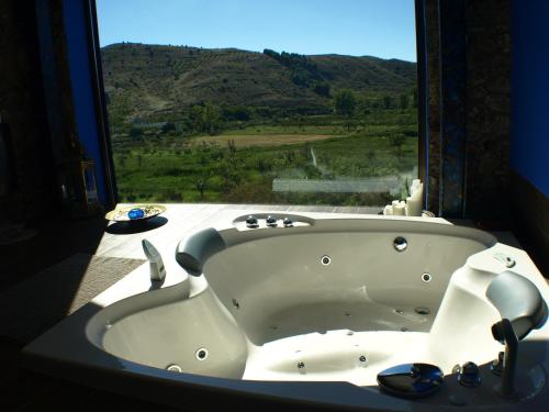 a bath tub in front of a window with a view at Suite Rural Carenas in Carenas