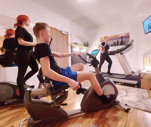 a man riding on an exercise bike in a gym at Gasthof Klug zum Ehrensepp in Modriach