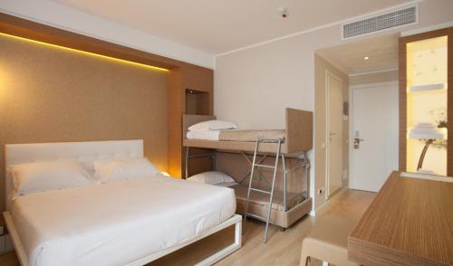 a bedroom with two bunk beds and a desk at Oxygen Lifestyle Hotel in Rimini