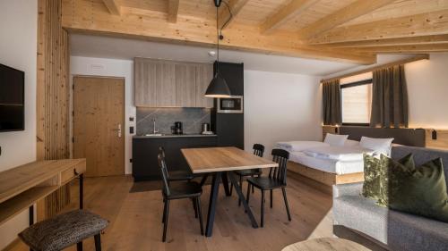 a hotel room with a bed and a table and chairs at Im Wiesengrund Apartments in Sesto