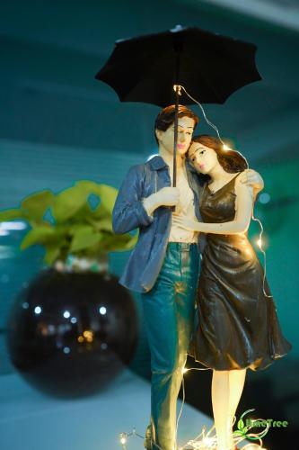 a figurine of a man and a woman holding an umbrella at Lime Tree Hotel Near 32nd Avenue Sector 29 Gurgaon in Gurgaon