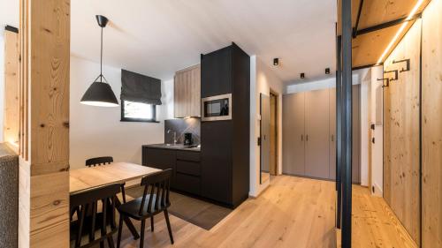 a kitchen and dining room with a table and chairs at Im Wiesengrund Apartments in Sesto