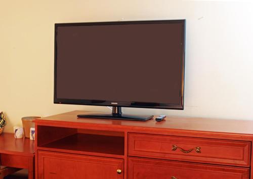 a flat screen tv sitting on top of a wooden dresser at Ramada by Wyndham Medicine Hat in Medicine Hat