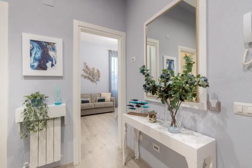 a living room with a mirror and a table with flowers at Casa Versilia Style in Viareggio