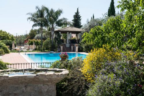 a swimming pool with a gazebo in a garden at Agriturismo Il Granaio Hotel & SPA in Modica
