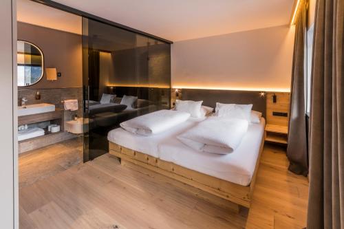 a bedroom with a large bed and a mirror at Im Wiesengrund Apartments in Sesto