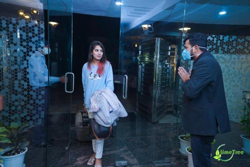 a man and a woman standing in front of a mirror at Lime Tree Hotel Near 32nd Avenue Sector 29 Gurgaon in Gurgaon